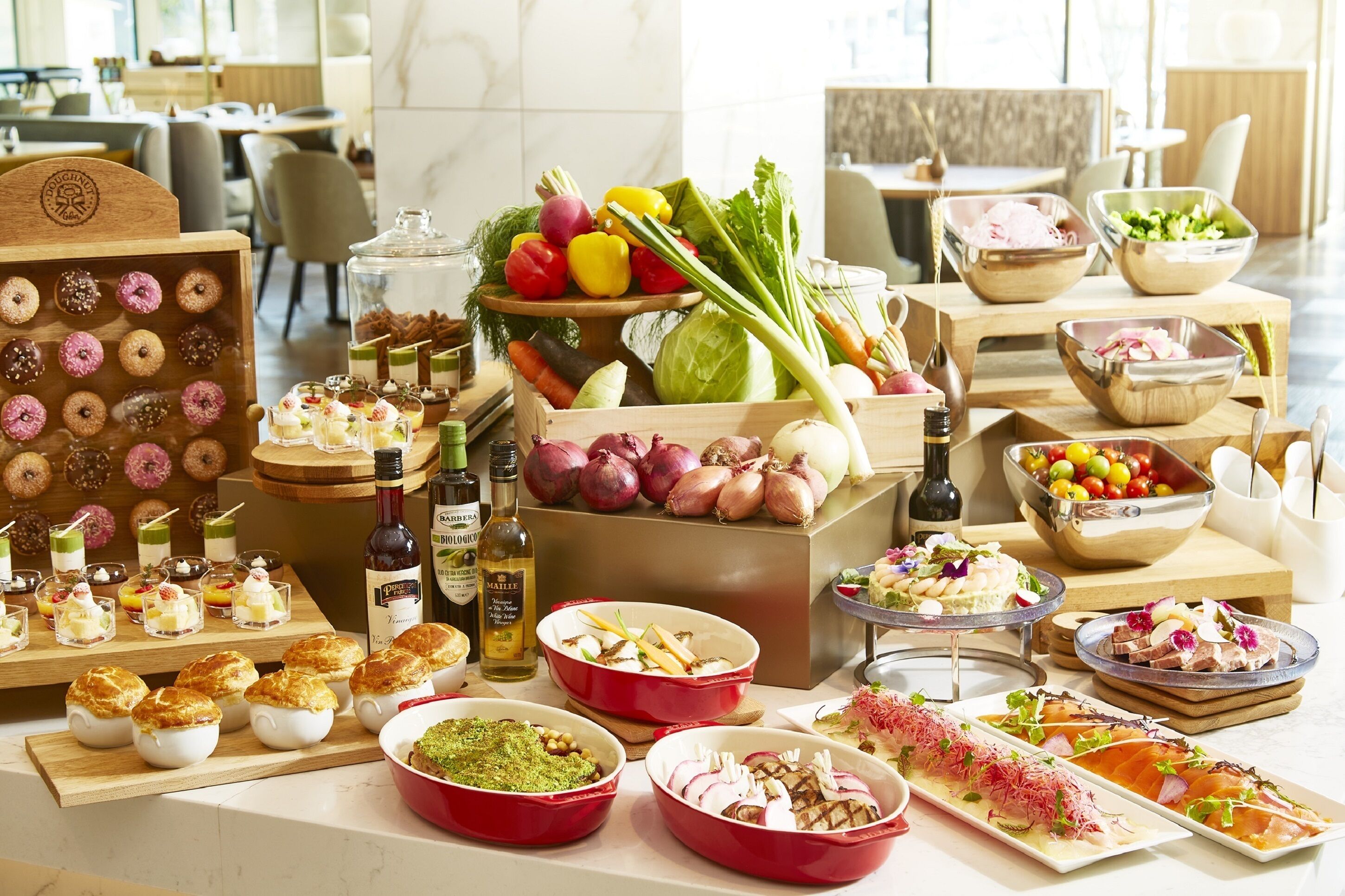 A variety of food and drink items displayed on a table in a well-lit room with a modern interior.