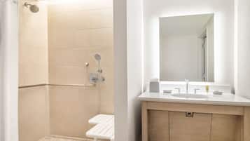 A modern bathroom with a shower, a sink, and a mirror.