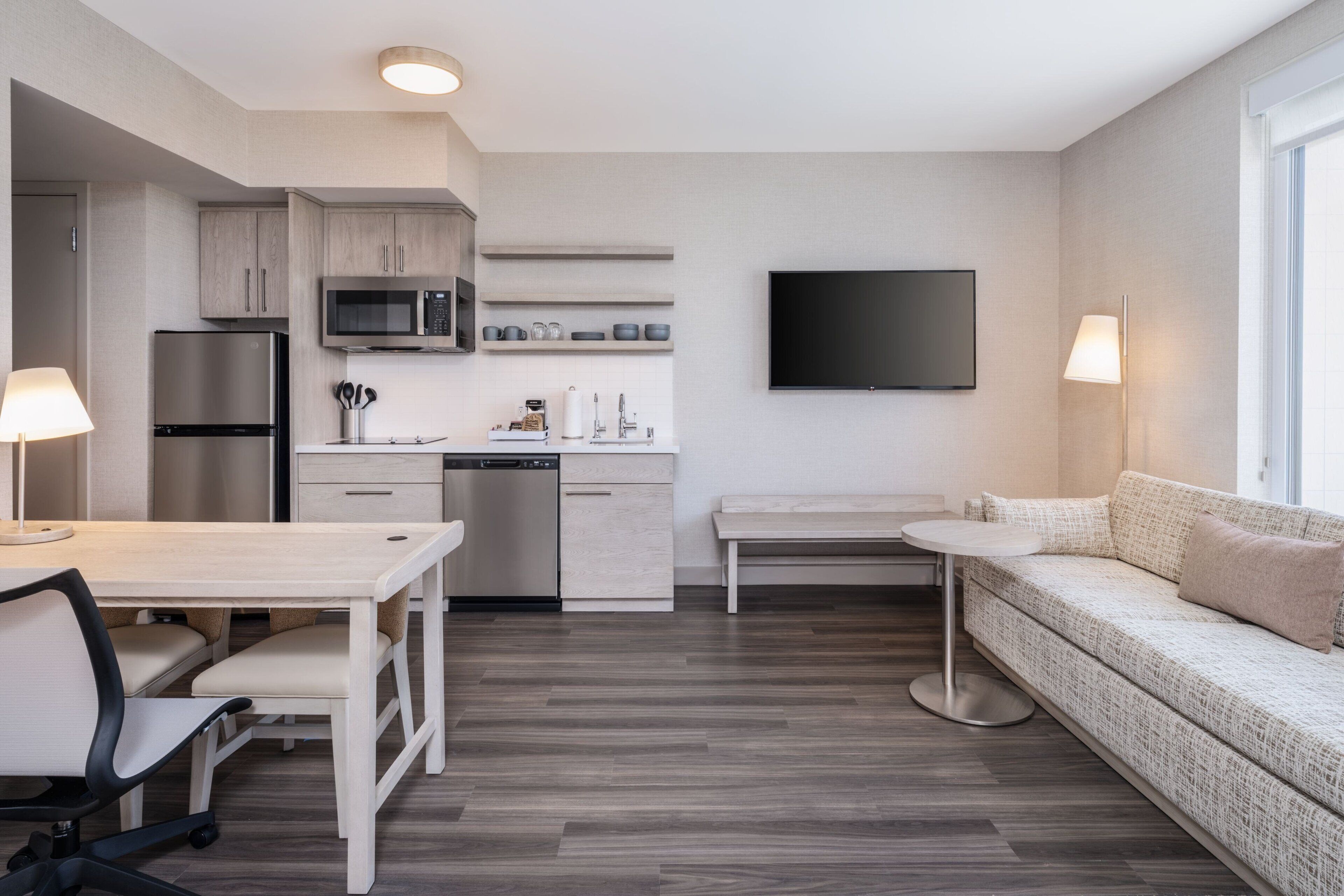 Una cocina moderna con comedor, sofá y televisor.