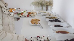 A buffet table with various food items, including a plate with a salad, a bowl of mixed nuts, and several small dishes with different foods. - Ferah Hotel (Kaş)