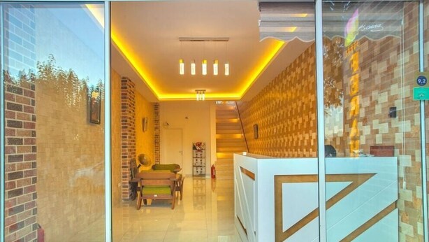 A reception area with a modern design, featuring a reception desk, seating area, and a staircase leading to an upper level. - Ferah Hotel (Kaş)