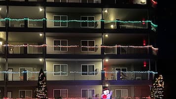 Un edificio de varios pisos con balcones decorados con luces de colores.