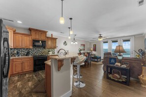 A modern kitchen with wooden cabinets, a microwave, and a dining area with a view.