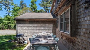 An outdoor wooden deck with a dining table set for six, surrounded by chairs. - Heated In-Ground Pool and New Central AC! (Brewster)