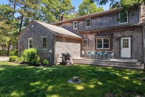 A two-story house with a front porch, a grill, and outdoor seating. - Heated In-Ground Pool and New Central AC! (Brewster)