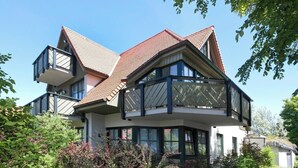 A two-story house with a balcony, large windows, and a sloped roof. - Moby Dick Wustrow (Ostseebad Wustrow)