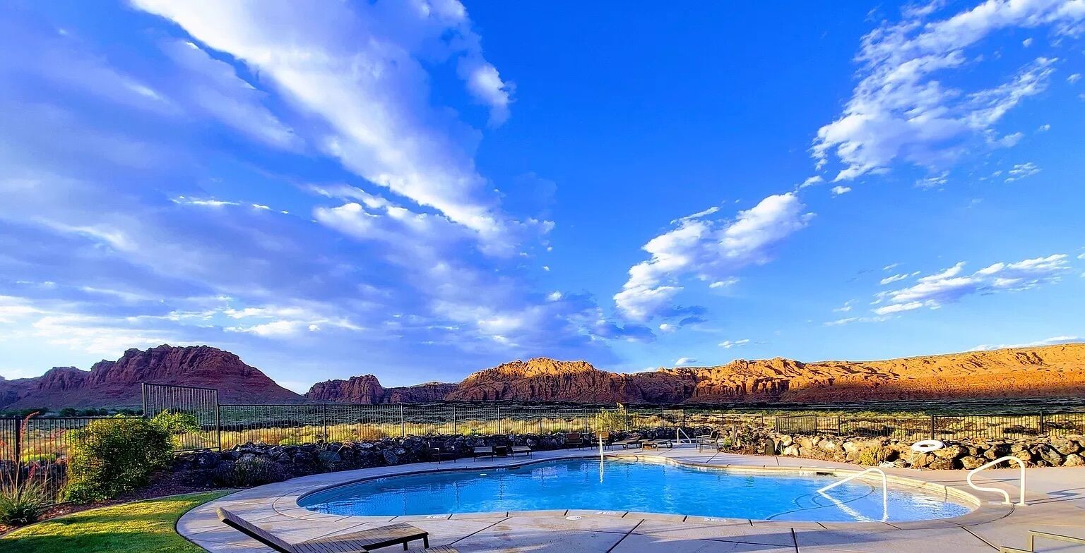 A swimming pool with a view of mountains and a clear sky.