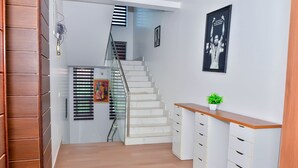 Eine Treppe mit Glastrennwand, Holzboden und einer weißen Wand mit einem Poster.