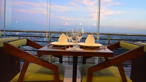 A table set for two with a view of the cityscape through large windows. - Rumah Highlands Hotel (Cebu)