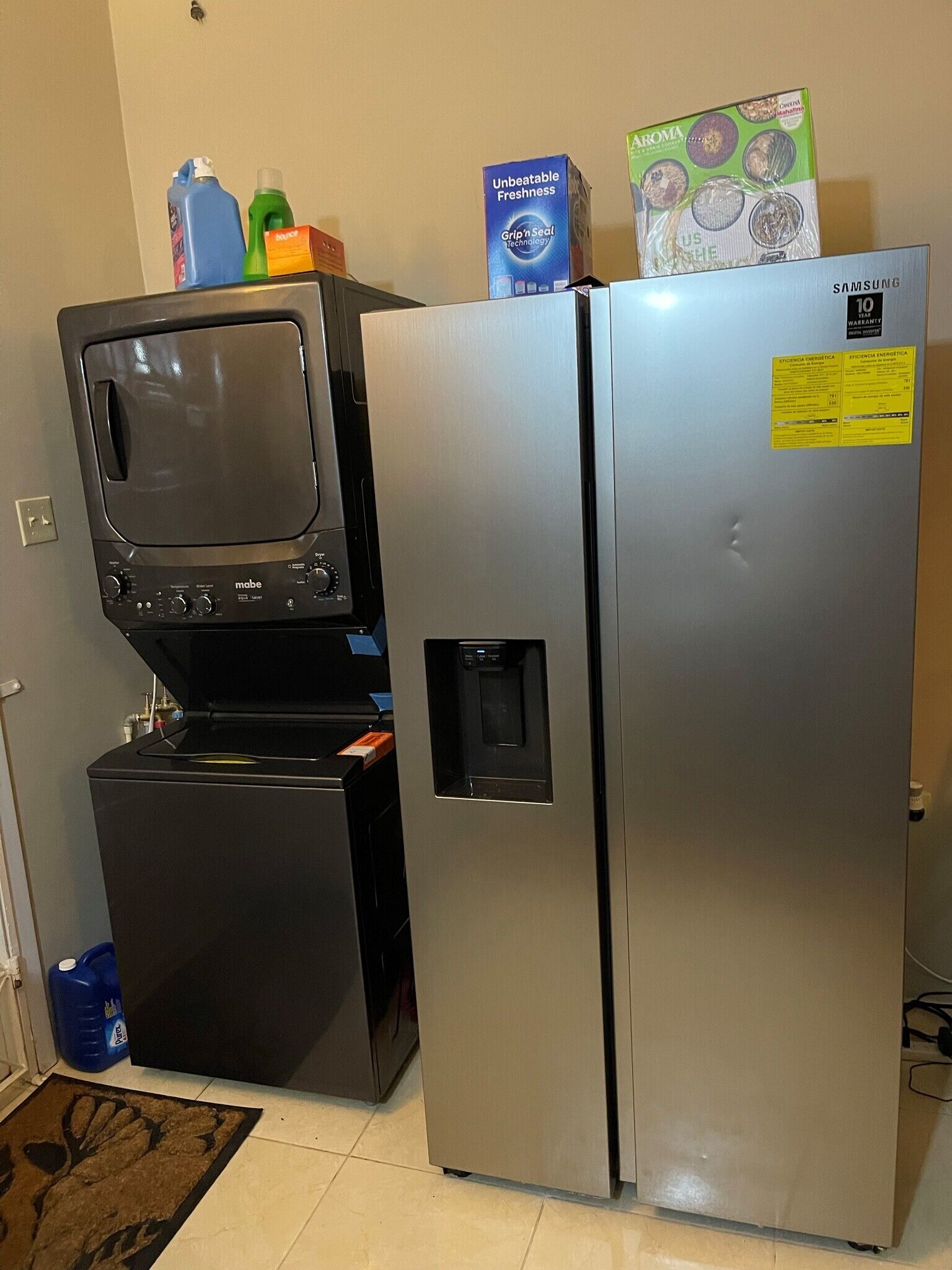 A compact kitchen with a refrigerator, a microwave, and a small freezer unit.