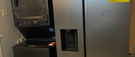 A compact kitchen with a refrigerator, a microwave, and a small freezer unit.