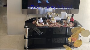 Een woonkamer met een flatscreen televisie aan de wand, een decoratieve console tafel eronder en een kleine waterpartij.
