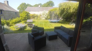 A patio with outdoor furniture, a trampoline, and a lawn. - Casa Camélias - LIMERZEL (LIMERZEL)
