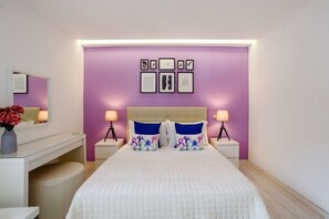 Une chambre à coucher avec un lit, des tables de chevet, un bureau et un miroir.