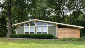A single-story house with a sloped roof, a garage, and a well-maintained lawn. - Bright & Clean Chalet with Hot Tub (Acme)