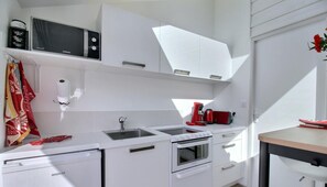 Enjoy meals and work sessions in this kitchen with microwave, compact oven, and stainless steel sink.