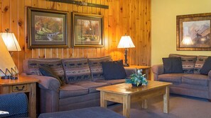 Relax in this inviting living room with two sofas, a coffee table, and artwork on the walls.