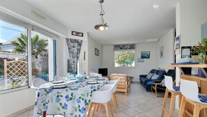 Un vaste espace de vie comprenant une table à manger pour quatre personnes, un canapé et un téléviseur.