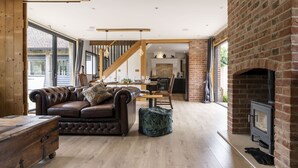 A spacious living area with a leather sofa, wooden coffee table, and a fireplace.