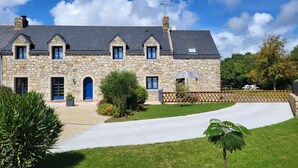 Un bâtiment en pierre doté de nombreuses fenêtres et d’une porte bleue.