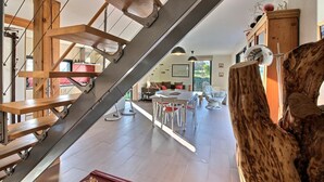 Un intérieur moderne agrémenté d’un escalier, d’un coin repas et de touches de bois.