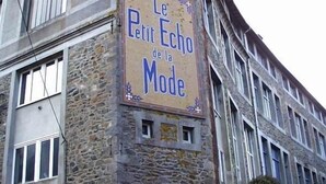 Un bâtiment dont la façade porte une enseigne indiquant : « Le Petit Écho de la Mode ».