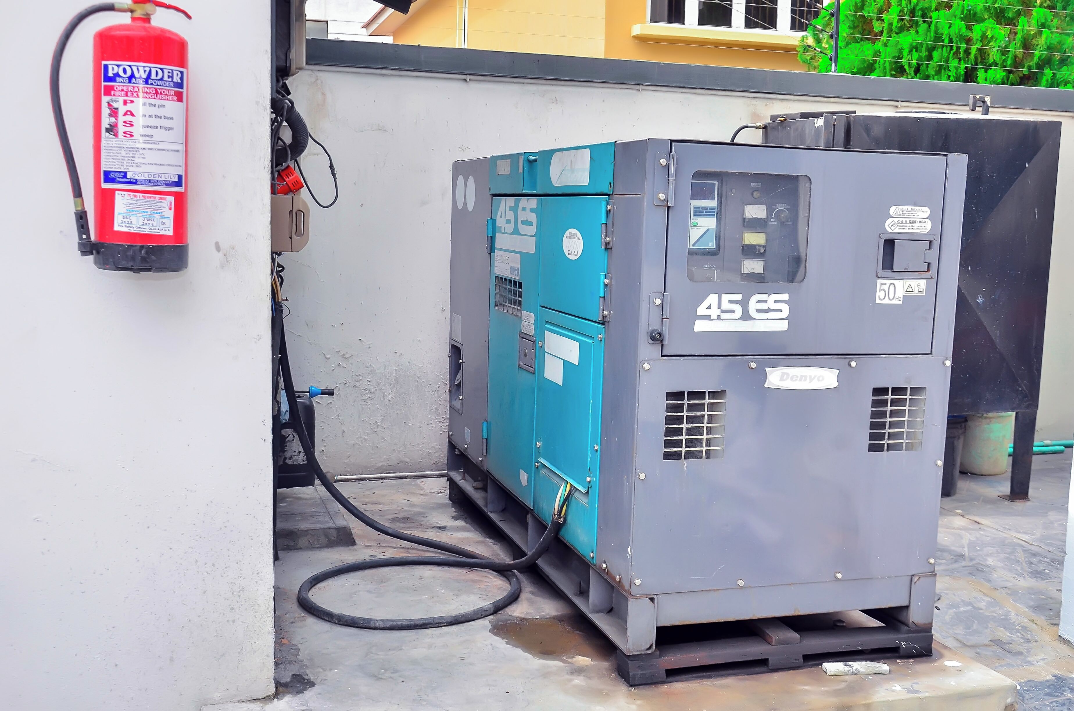 A portable generator labeled '45 ES' connected to a fire extinguisher.