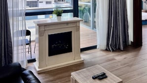 A modern living room with a fireplace, large windows, and a view of the cityscape. - ATLANTA @ AMERICA LUXURY EXTENDED STAY (Lagos)