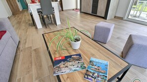 A modern living room with a wooden coffee table, a potted plant, and two travel brochures. - du Talbert - Pleubian (PLEUBIAN)