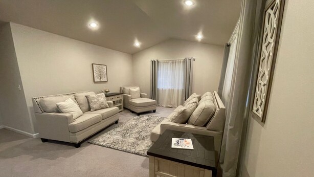 A living room with a beige sofa set, a coffee table, and a patterned rug. - Spacious and Peaceful (College Place)