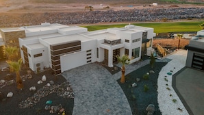 Ein modernes Haus mit geräumiger Terrasse, Pool und Blick auf die umliegende Landschaft.
