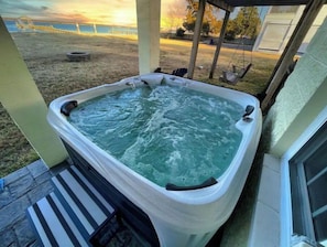 Un bain à remous avec vue sur l’océan et une cour verdoyante.