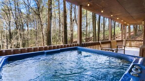 A hot tub with a wooden deck and a view of a forest. - Escape to Moose Crossing – A Cozy Cabin Retreat in Blue Ridge, GA! (Blue Ridge)