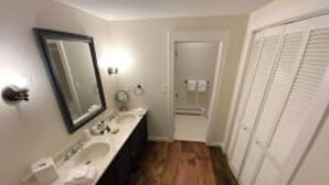 A bathroom with a double sink vanity, a mirror, and a toilet. - Deluxe 2xQueen & fireplace (Dover)