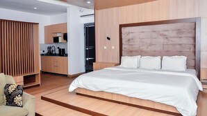 A modern bedroom with a large bed, wooden headboard, and a built-in desk area. - LAS VEGAS NEVADA @ AMERICA LUXURY EXTENDED STAY (Lagos)
