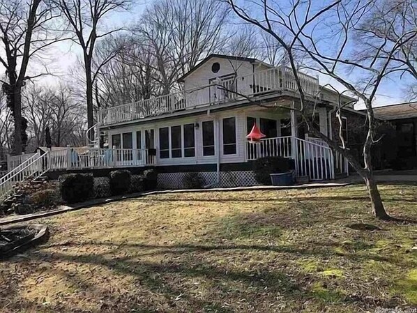 A two-story house with a porch and a small deck. - Relax on the edge of Little Red @ Griffin Little Red River Cabin (Heber Springs)
