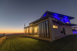A modern house with large glass windows, a flat roof, and a well-lit exterior. - Villa with private Jacuzzi, relaxing wellness weekends and holidays, seaside (Plougonvelin)