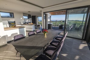 A modern kitchen with a dining area, large windows, and a view of the countryside. - Villa with private Jacuzzi, relaxing wellness weekends and holidays, seaside (Plougonvelin)