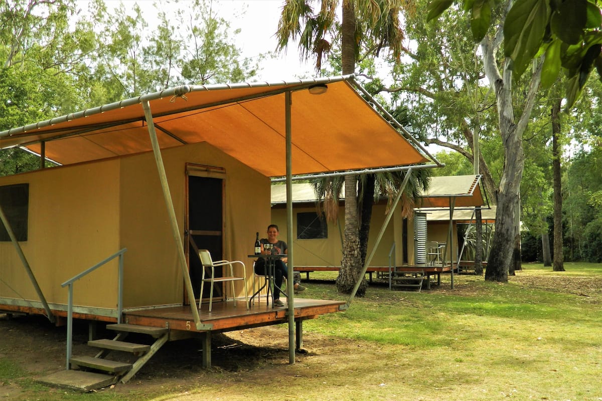 A single-roomed, two-story structure with a balcony, surrounded by trees.
