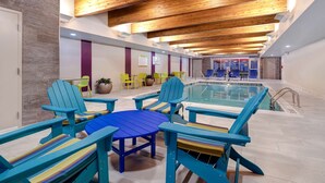 A pool area with blue Adirondack chairs and a blue table. - Home2 Suites by Hilton Wilkes-Barre (Wilkes-Barre)