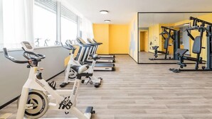 A gym with exercise bikes, treadmills, and weight machines. - Atour Hotel (Jiaxing)