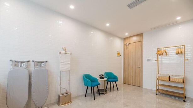 A modern bathroom with two large mirrors, a wooden door, and a shelf with baskets. - Atour Hotel (Jiaxing)