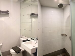 A modern bathroom with a toilet, sink, and shower. - We Hotel Linggau (Lubuklinggau)