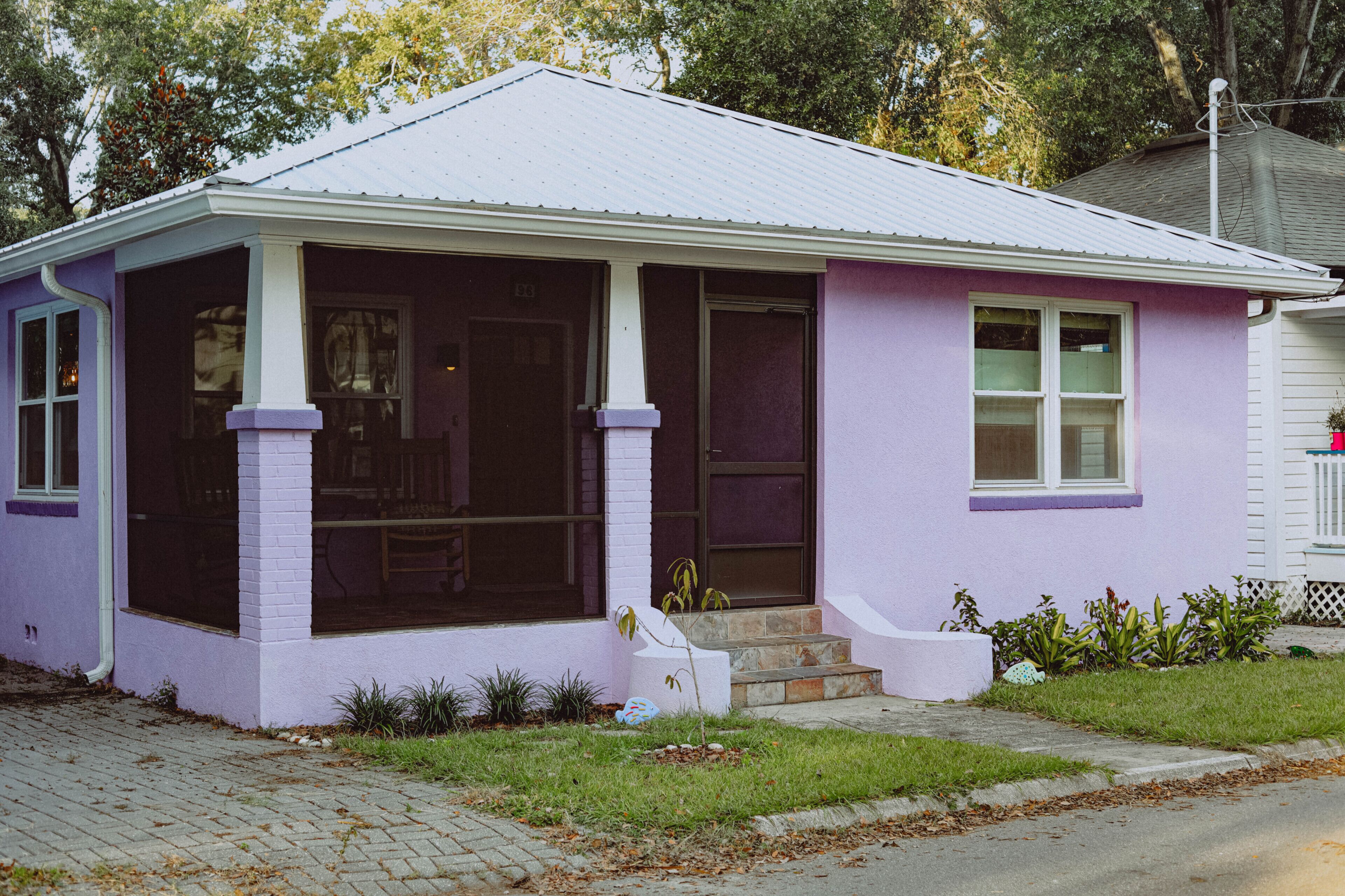 Ein einstöckiges Haus mit Veranda, Eingangstür und kleinem Vorgarten.