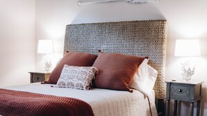 A neatly made bed with a patterned headboard, two bedside lamps, and a small bedside table with a drawer. - Outdoor Oasis in Historic St. Augustine (Saint Augustine)