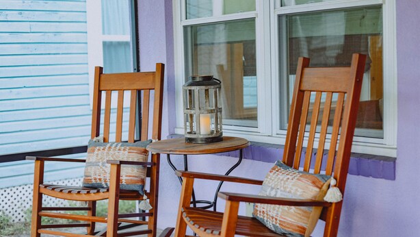 Two rocking chairs with cushions, a small table, and a lantern on a porch with a window. - Outdoor Oasis in Historic St. Augustine (Saint Augustine)