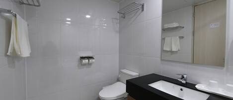 Un baño moderno con un inodoro blanco, un lavabo negro y un espejo.