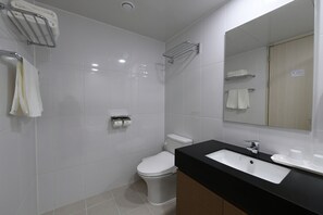 A modern bathroom with a white toilet, a black sink, and a mirror.