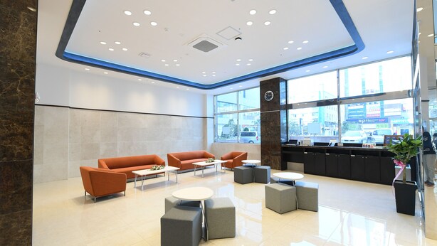 A modern lobby with orange sofas, grey ottomans, and a reception desk. - Toyoko Inn Changwon (Changwon)