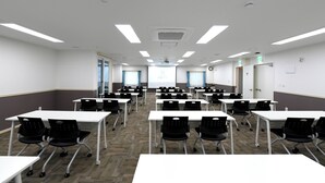 A conference room with white tables and black chairs, equipped with a projector screen and a whiteboard. - Toyoko Inn Changwon (Changwon)